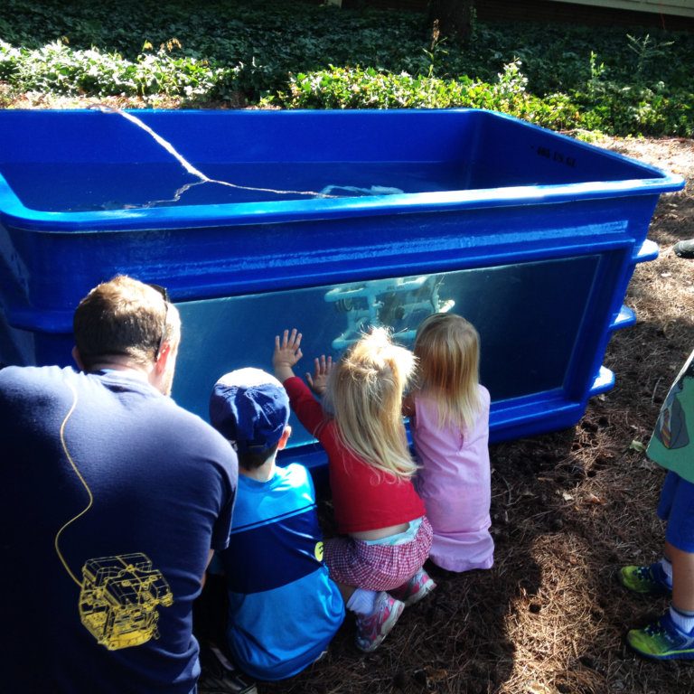 6 Ph.D. student Ryan Sibert directs the young ROV pilots at a game in Athens, Georgia. Photo Credit: Christine Laporte/ECOGIG.