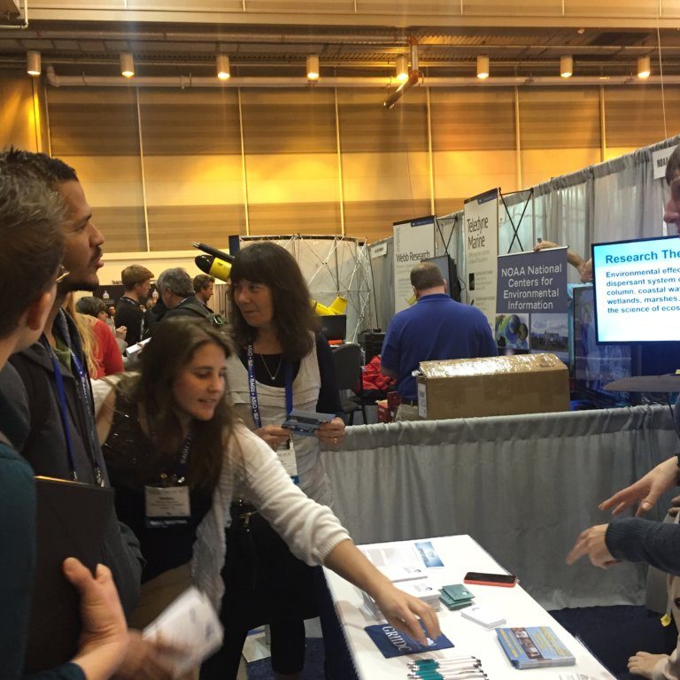 GoMRI Booth Ocean Sciences – Credit Lauren Showalter GRIIDC 2 Staff from the GoMRI Management Team interacts with conference attendees at the GoMRI booth. Photo Credit: Lauren Showalter.